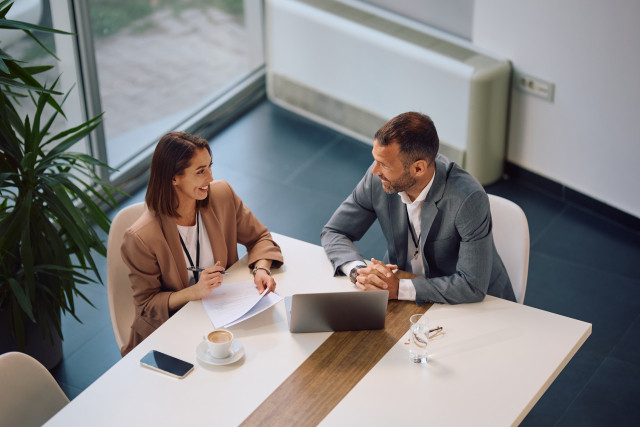 business man and business woman talking at a desk